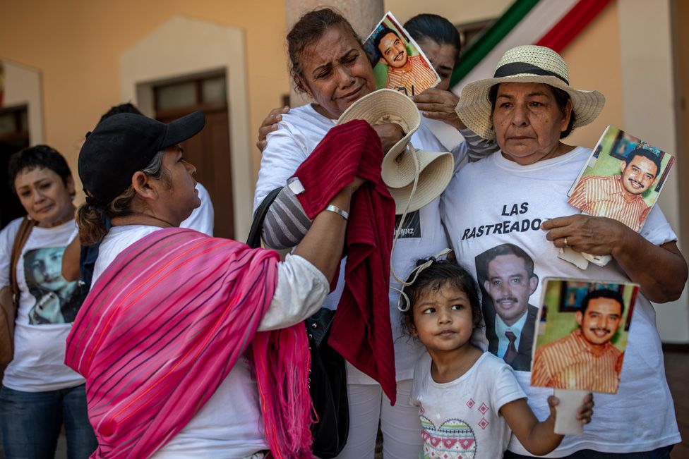 A family holds signs of a missing loved one during a march in el Fuerte, Sinaloa