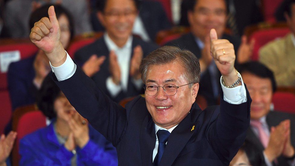 South Korean presidential candidate Moon Jae-in (C) of the Democratic Party reacts as he watches screens showing the result of exit polls of the presidential election at a hall of the National Assembly in Seoul on May 9, 2017.