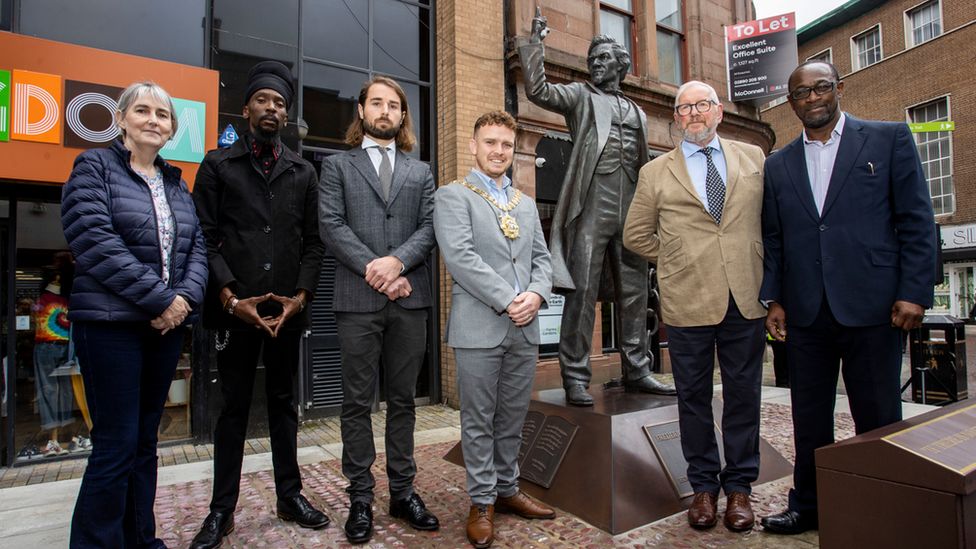 Anna Slevin from the Department for Communities, Takuri Makoni from the African and Caribbean Support Organisation NI (ACSONI), sculptor Hector Guest, Belfast Lord Mayor Councillor Ryan Murphy, sculptor Alan Beattie Herriot and Reverend Dr Livingstone Thompson from ACSONI at the unveiling of a statue of anti-slavery campaigner and author Frederick Douglass in Belfast city centre.