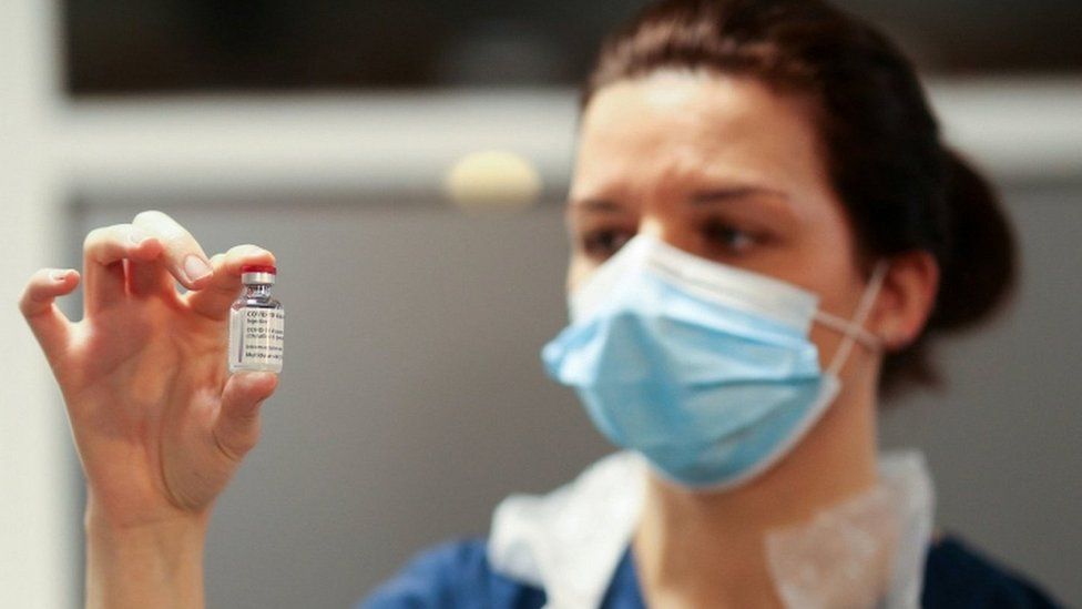 A health worker holds a Covid vaccine