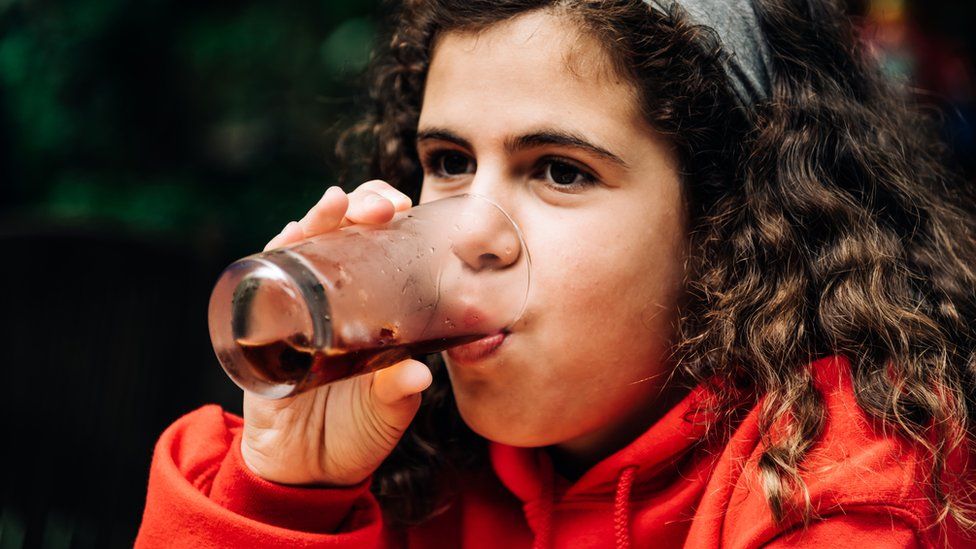A girl drinking a soft drink
