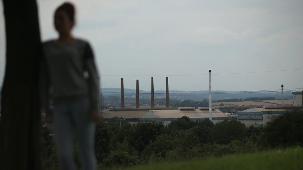 Woman poses in front of Rotherham skyline