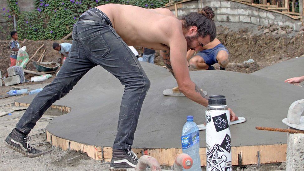 Topless volunteer adds finishing touches to one of the skate park's features