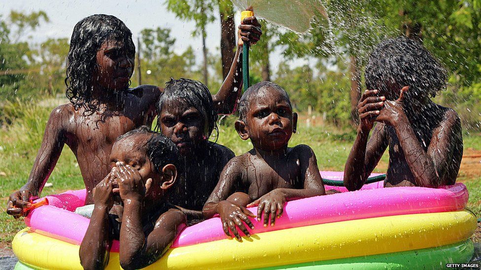 Gumatj Aboriginal children escaping the searing summer heat in their pool at Yirrkala in Arnhem Land