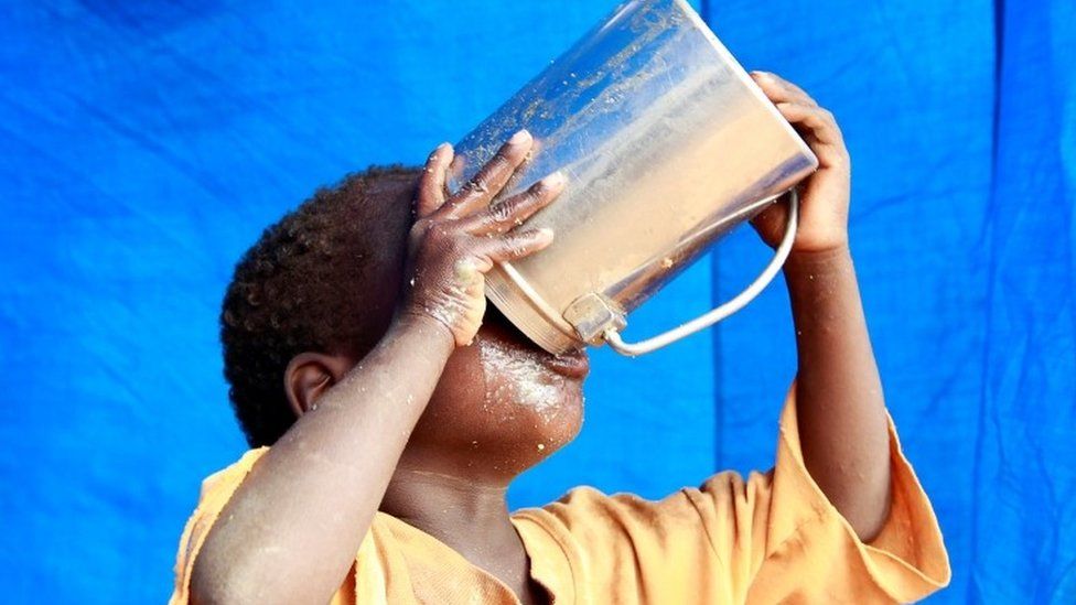 A newly-arrived refugee child drinks inside their tent in Dadaab refugee camp