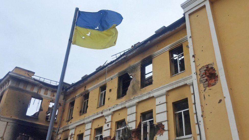 Ukrainian national flag in front of a school in Kharkiv