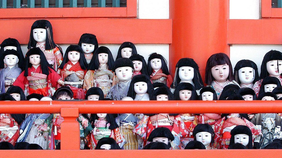 Traditional Japanese dolls lined up at the Awashima Shrine