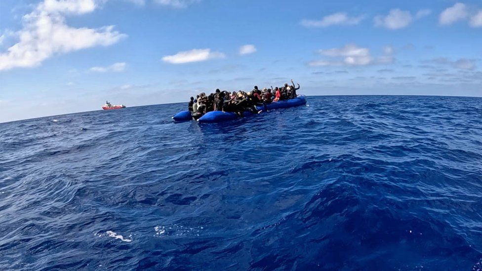 The blue rubber boat carrying the migrants, as pictured from the rescue boat approaching it