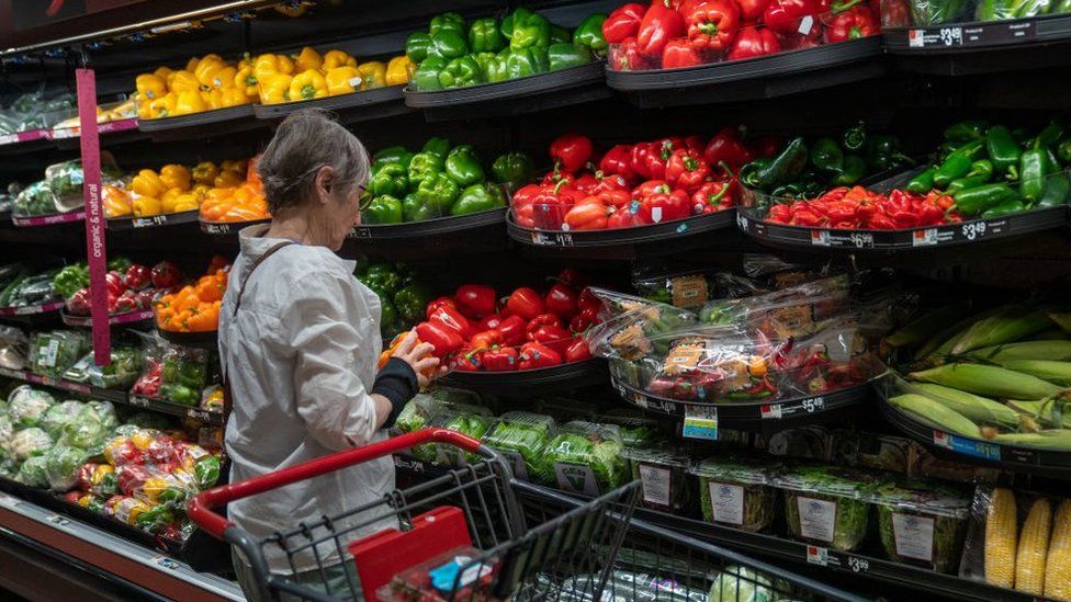 A person looks at peppers at a grocery store