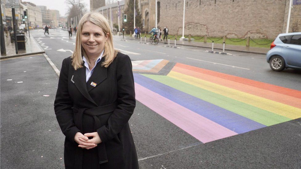 Hannah Blythyn by the Pride flag on Castle Road