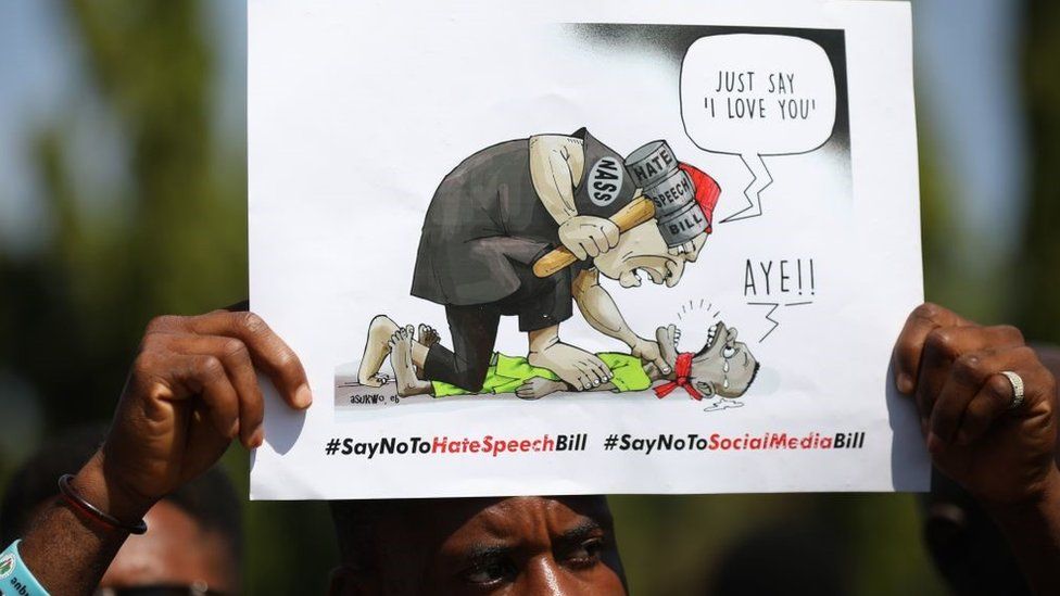 A protester holds a placard in front of Nigeria's National Assembly during a protest on the Hate Speech Bill and Social Media Bill in Abuja, on November 27, 2019