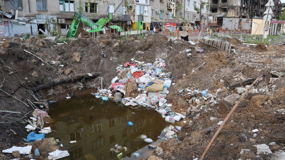 An explosion crater filled with water and rubbish in Mariupol on 29 April