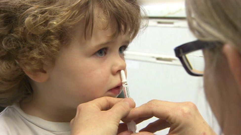 A child have a flu vaccine by nasal spray