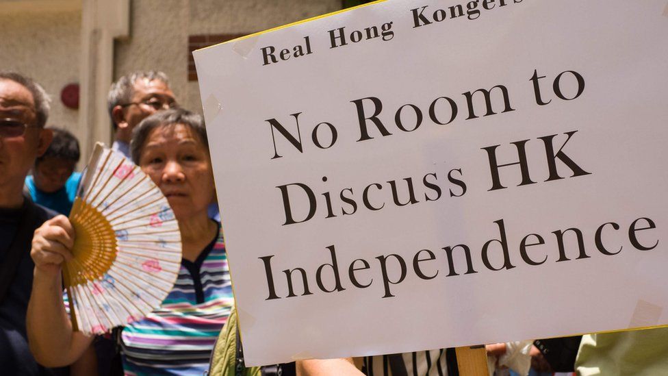 Protesters holding a banner 'Nor room to discuss HK independence'