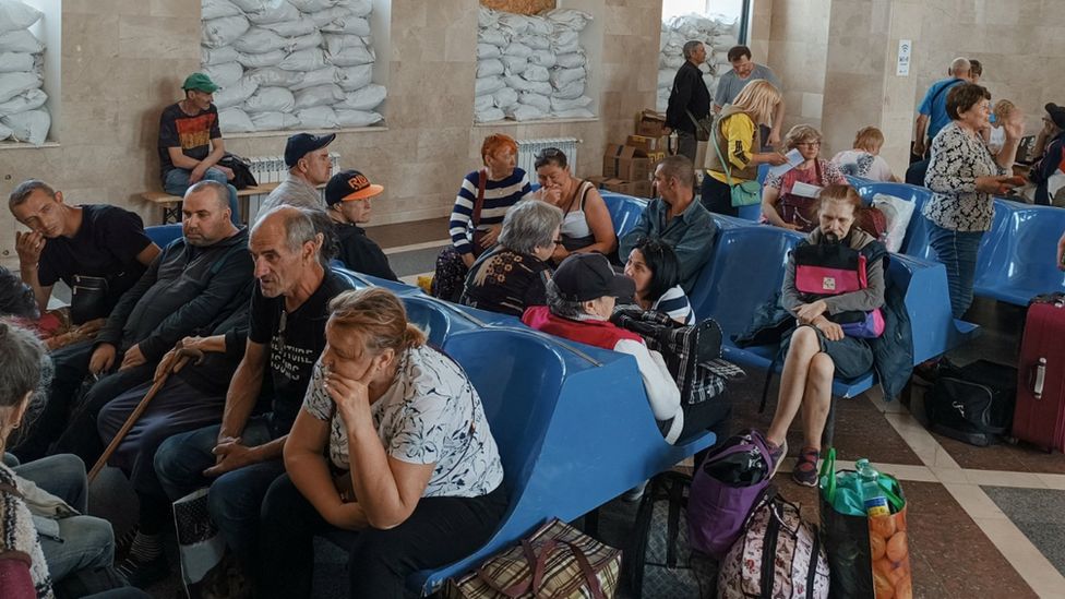 Local residents wait for an evacuation train at a railway station in Kherson