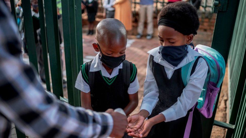 Students astatine  a Johannesburg schoolhouse  sanitise their hands astatine  the schoolhouse  entranceway  successful  2021