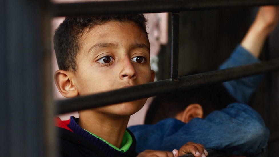 A child waits for food in Gaza