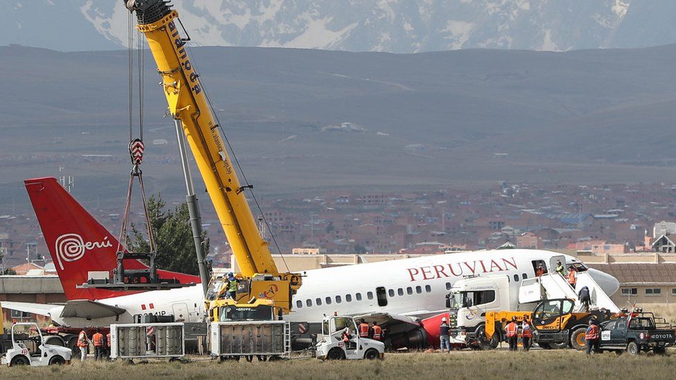 Rescue workers at the El Alto International Airport in Bolivia try to tow a stranded plane, 22 November 2018.