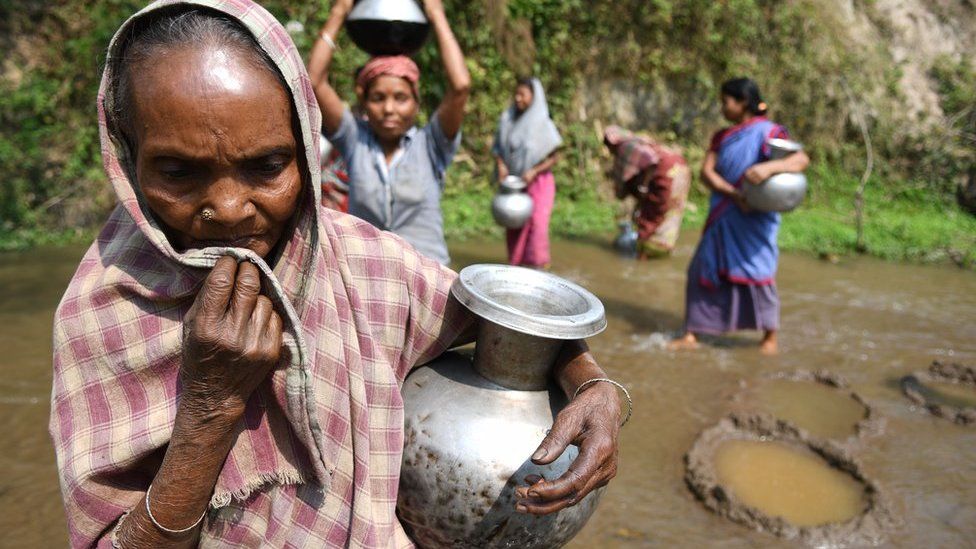 Indian tribal women collect water from small stream for drinking on 3 April 2018 near Agartala in India.