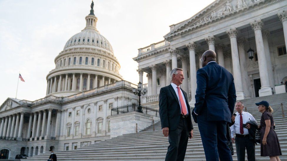 Republican Senator Tommy Tuberville talks with Democrat Raphael Warnock outside the Senate side of the U.S. Capitol