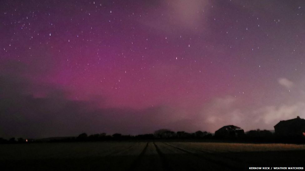 Tinges of purple in the night sky across a field