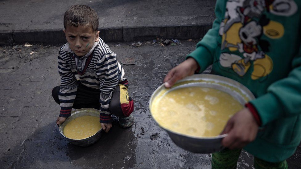 Gazan children with bowls of soup in Rafah