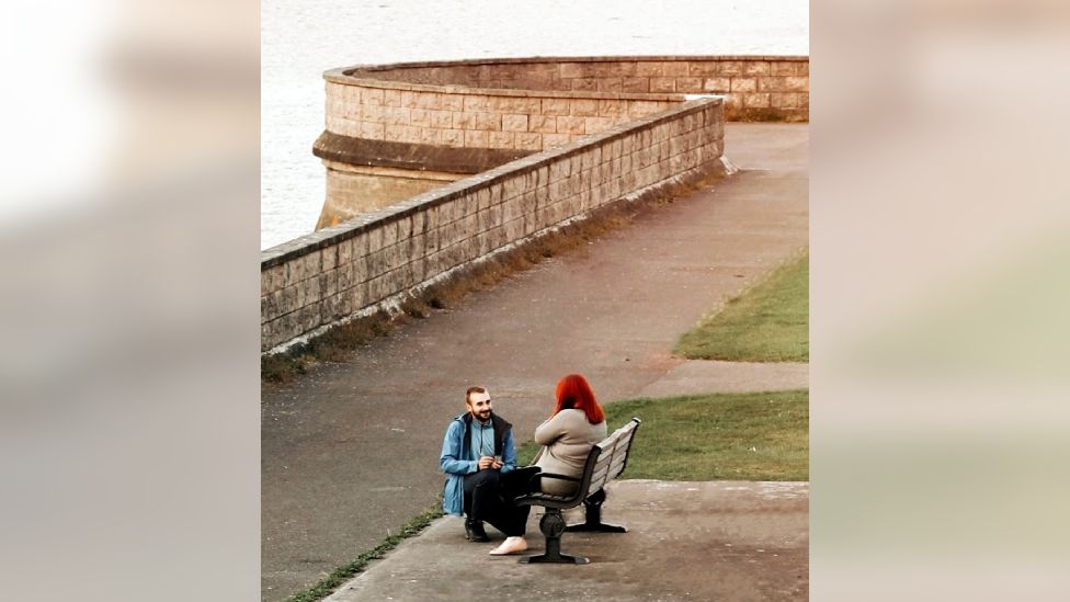 man proposing to woman on bench