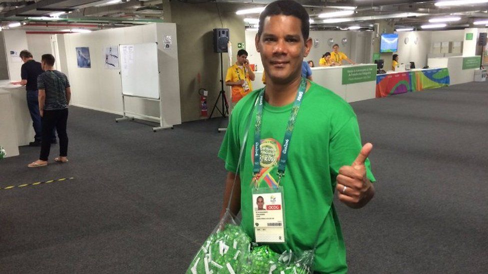 Man hands out condoms at the Olympic village in Rio