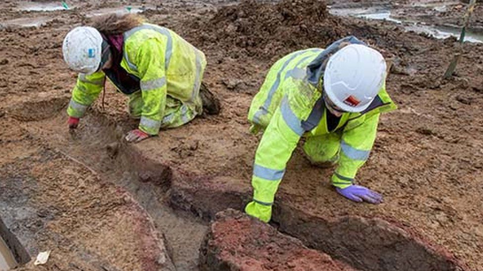 Archaeologists excavating the Roman kiln found at Field 44 on the A428