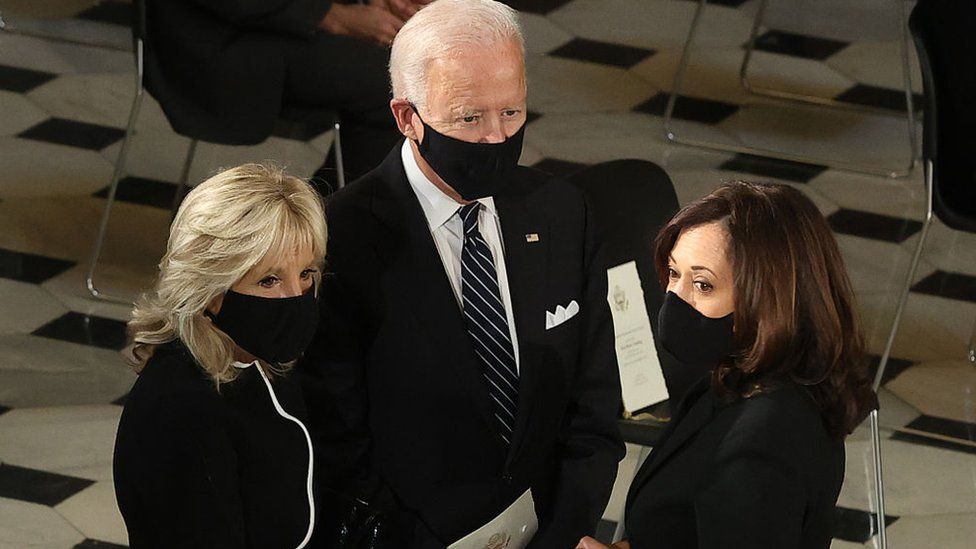 Mr Biden and his wife Jill and running mate Kamala Harris (right)