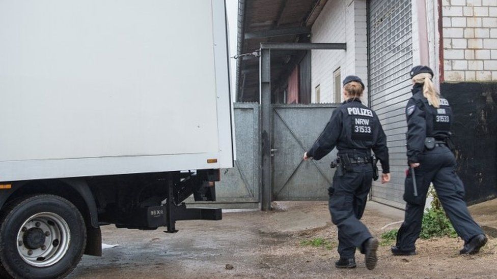 Policewomen walk towards a warehouse in Pulheim, western Germany, on November 15, 2016