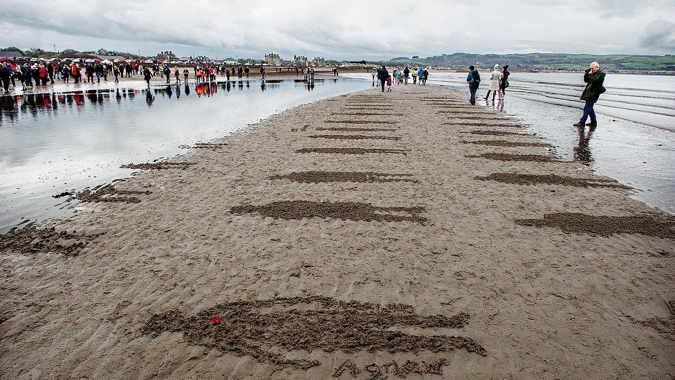 Representations of soldiers on Ayr beach poignantly disappear under the water