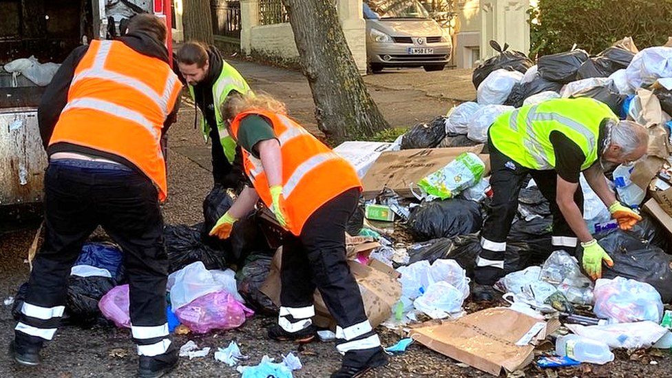 Refuse workers clear a street in Brighton