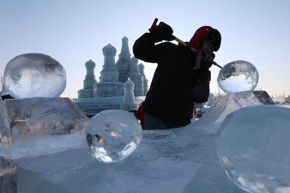 A worker carves an ice sculpture