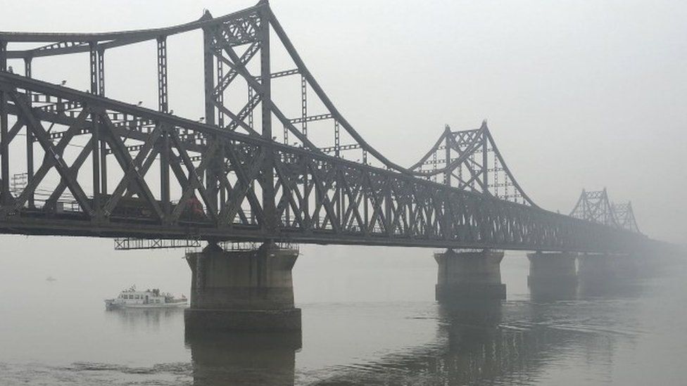 Trucks move across the bridge linking North Korea with the Chinese border city of Dandong - March 2016