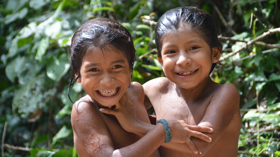 Two Awa children smile for the camera in 2014