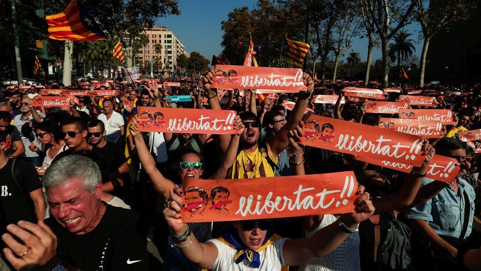 Demonstrators hold up banners reading "Freedom" in reference to the jailed leaders of Catalan pro-independence movement