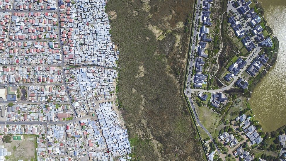 Una toma aérea del lago Michelle, una valiosa y rica finca en Ciudad del Cabo, Sudáfrica, y una comunidad más pobre, Masiphumelele.