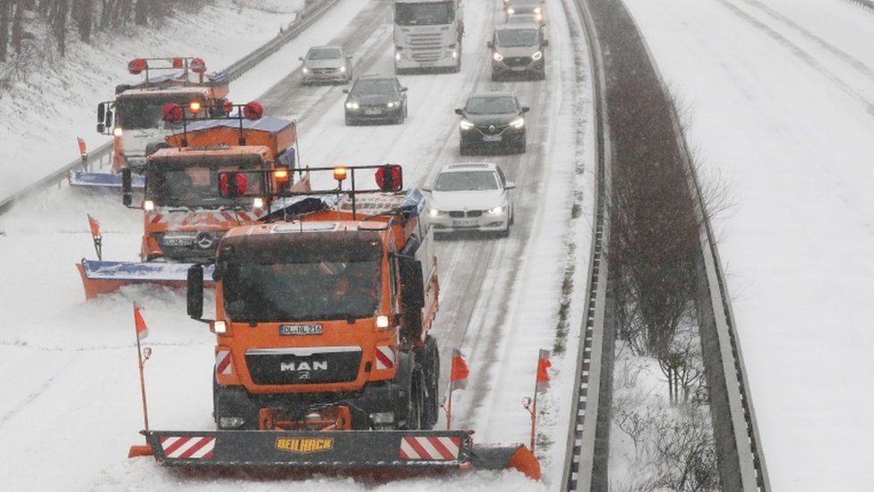 Snow ploughs clear snow on the snow-covered Autobahn A1 highway near Wildeshausen, northern Germany