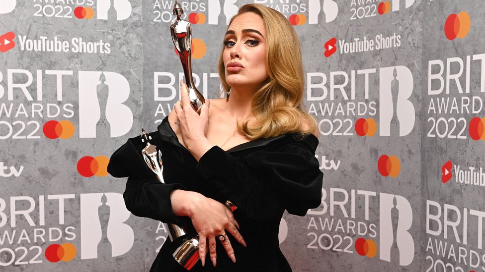 Адель позирует со своей наградой в медиа-зале во время церемонии вручения наград BRIT Awards 2022 на арене O2 8 февраля 2022 года в Лондоне, Англия.