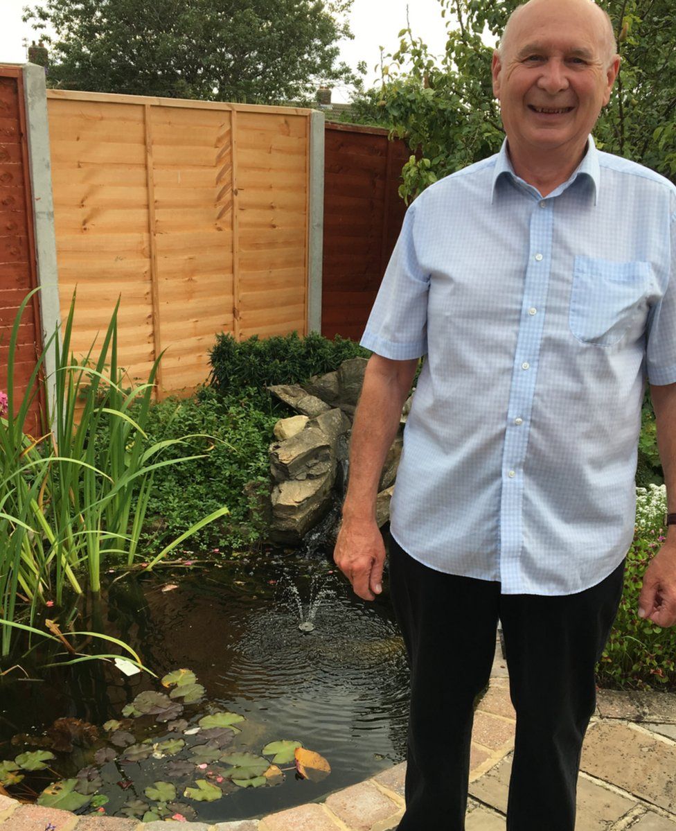 Francis Sherwood standing in front of his fish pond