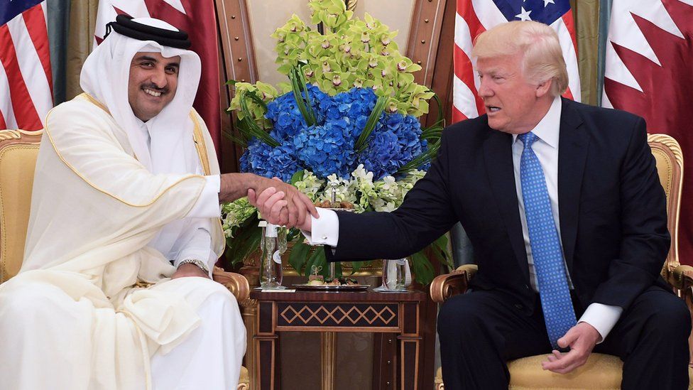 US President Donald Trump (R) shaking hands with Qatar's Emir Sheikh Tamim Bin Hamad Al-Thani
