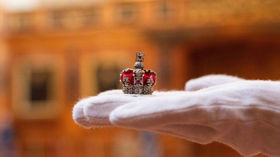 tiny replica of crown jewels held by white glove