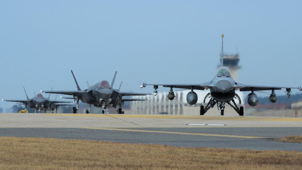 In this handout image taken on 3 December by U.S. Air Force and released on 4 December, U.S. Air Force F-16 Fighting Falcon (R) and F-35A Lightning II fighter jets taxiing at Kunsan Air Base on 3 December 2017 in Kunsan, South Korea.