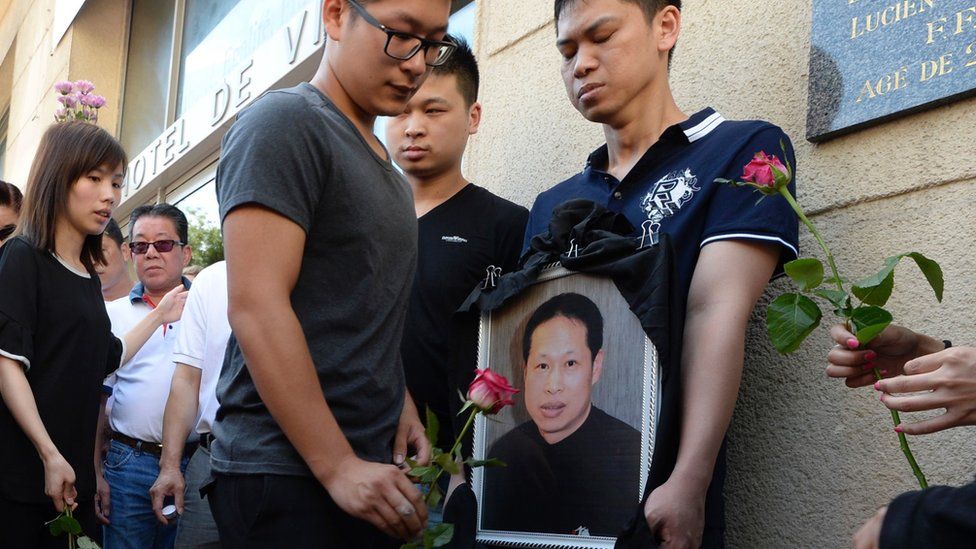 Family members and relatives hold a portrait of Zhang Chaolin outside the town hall in Aubervilliers, north-eastern suburbs of Paris, 14 August