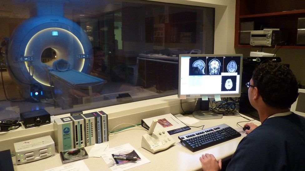 Scientist looking at an MRI scanner