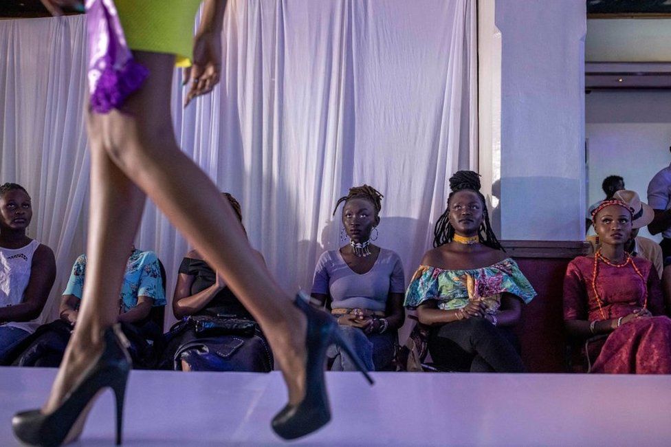 People watch a model on a runway at East Africa International Fashion Week.