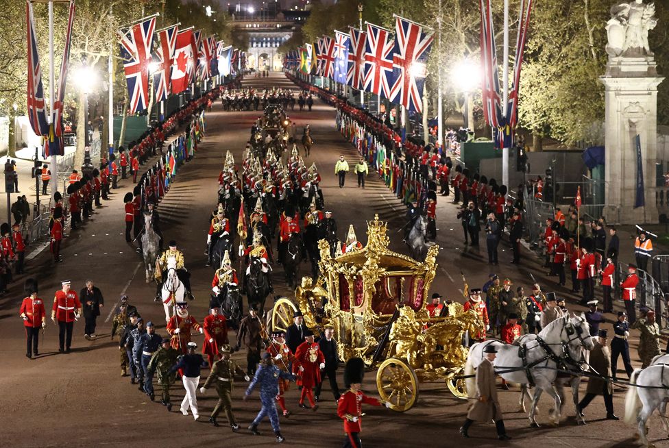 The Gold State Coach is ridden alongside members of the military during a full overnight dress rehearsal of the Coronation.