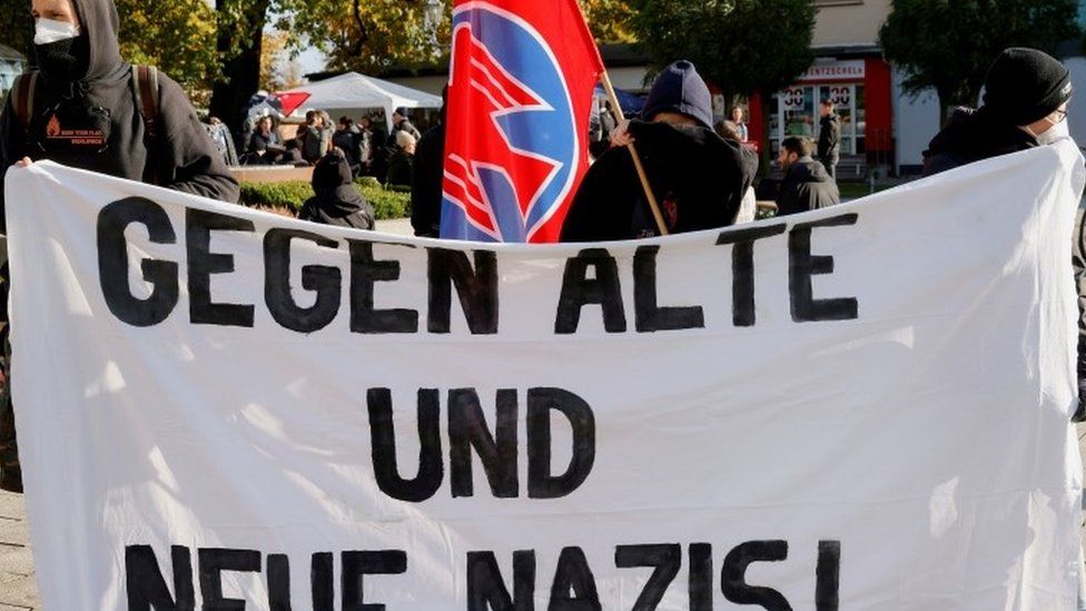Protesters hold a banner reading 'Against Old And New Nazis!' during a counter-demonstration
