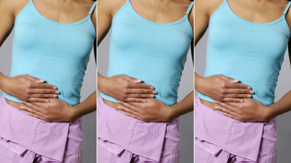 Woman clutching her midriff with period pains